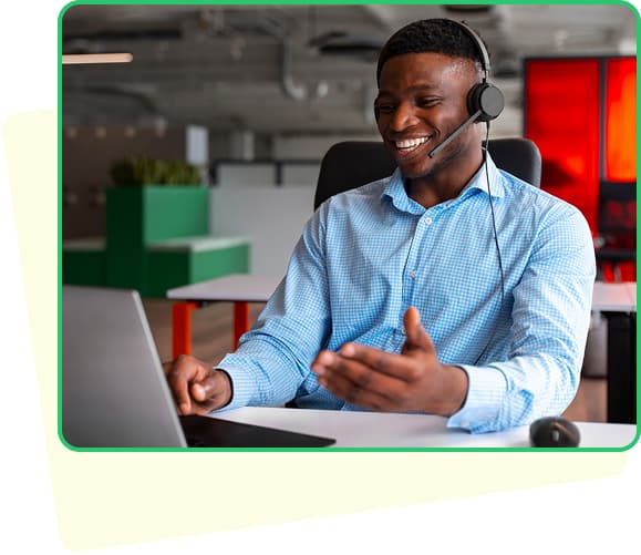A man holding dollars and a laptop smiling with a green background